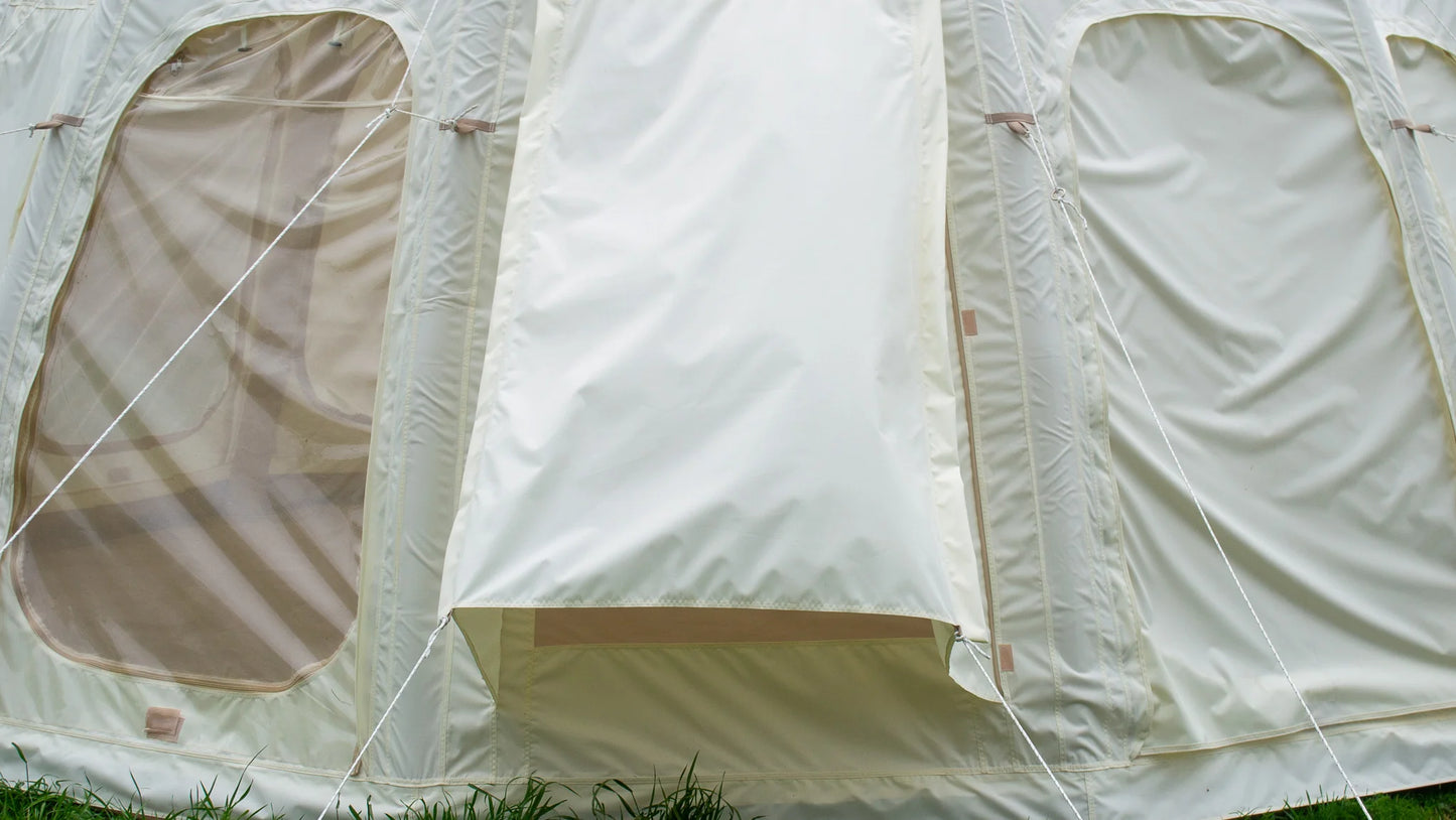 Close-up of a beige tent with mesh windows on a grassy background