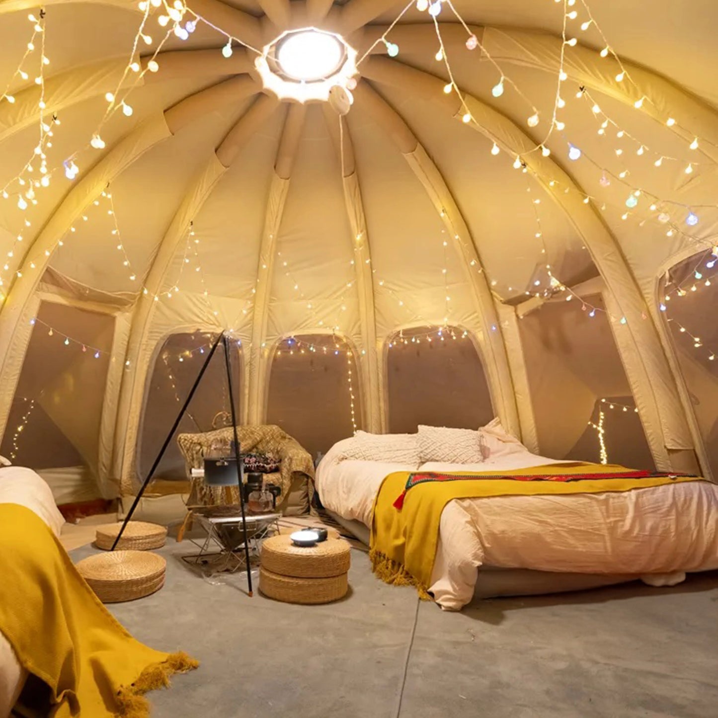Indoor dome room with string lights, bed, and furniture.
