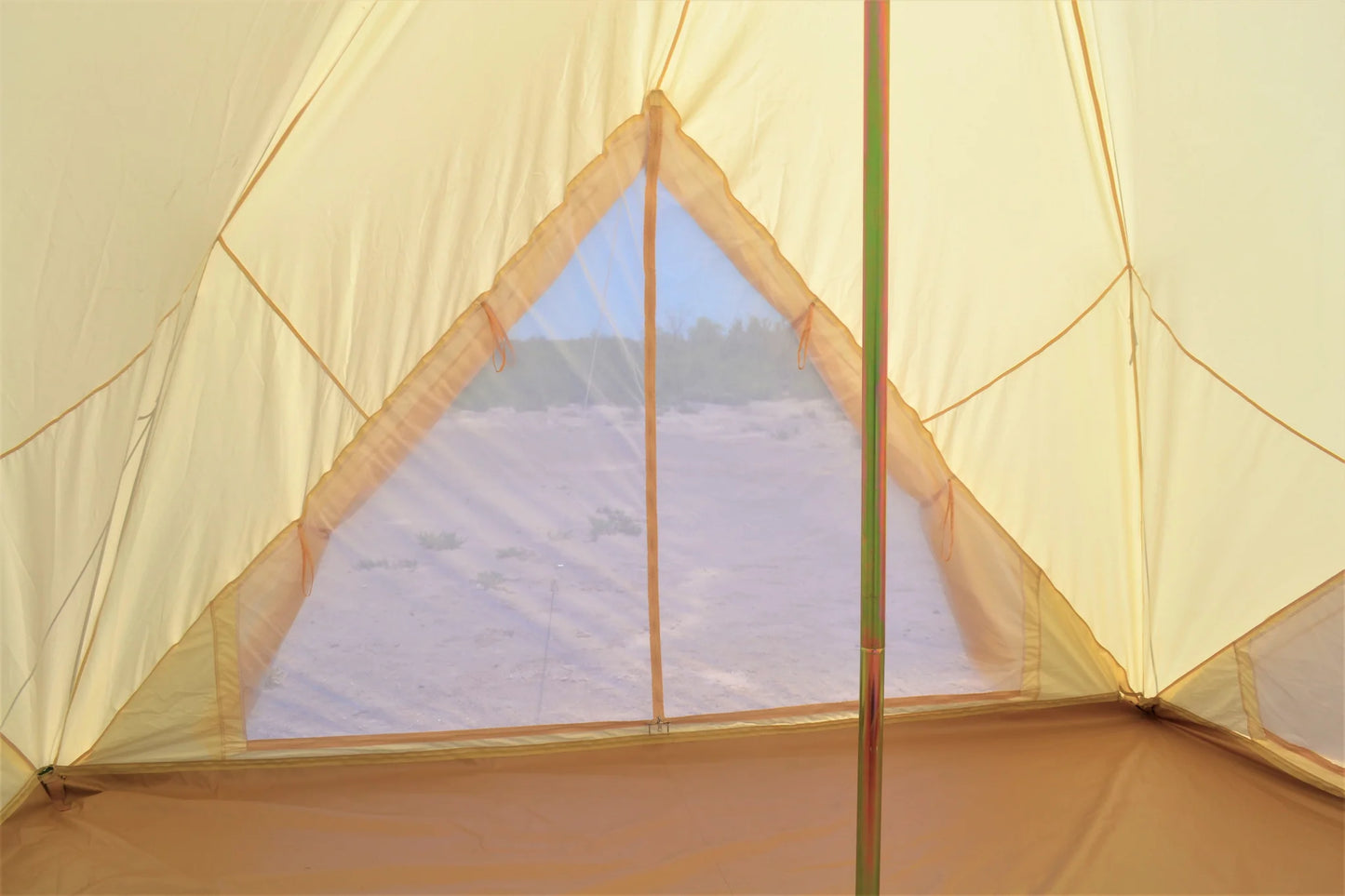 Inside view of a beige tent with a clear plastic window showing a scenic landscape.
