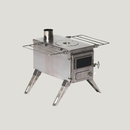A small, portable, silver-colored wood burning stove with a visible pipe and Ignition system, designed for outdoor use.