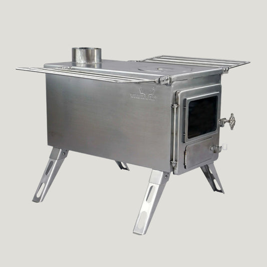 A silver-colored, large wood burning stove with a visible firebox and legs, designed for glamping setups and bell tent use.