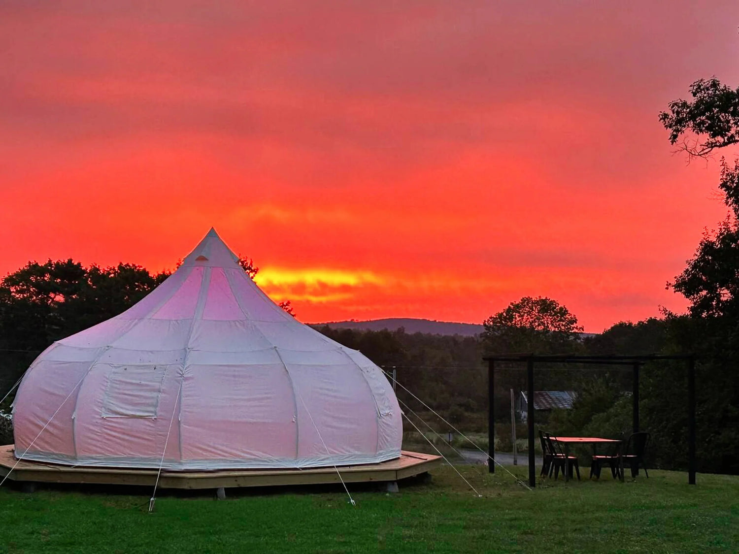 Glamping tent with a vibrant sunset sky