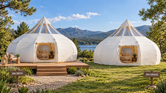  A glamping tent on a wooden platform deck beside a tent set up directly on grass
