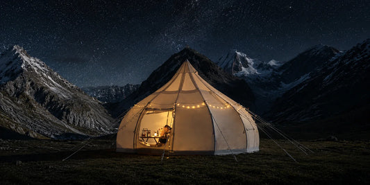  Glamping tent at night under a star-filled sky with the Milky Way visible above and warm light glowing inside