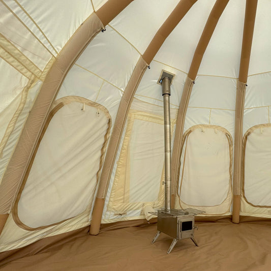 Winnerwell wood stove burning inside a Jellyfish air beam glamping tent