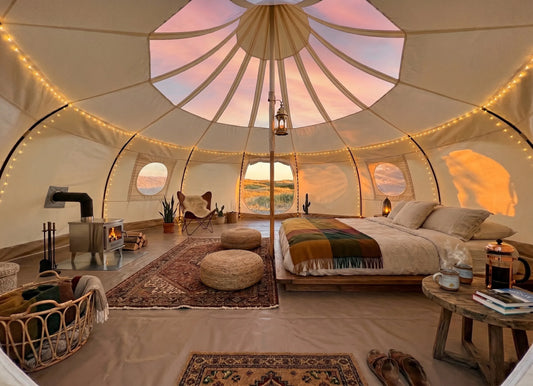  Furnished glamping tent interior with bed and string lights styled for Airbnb listing photography