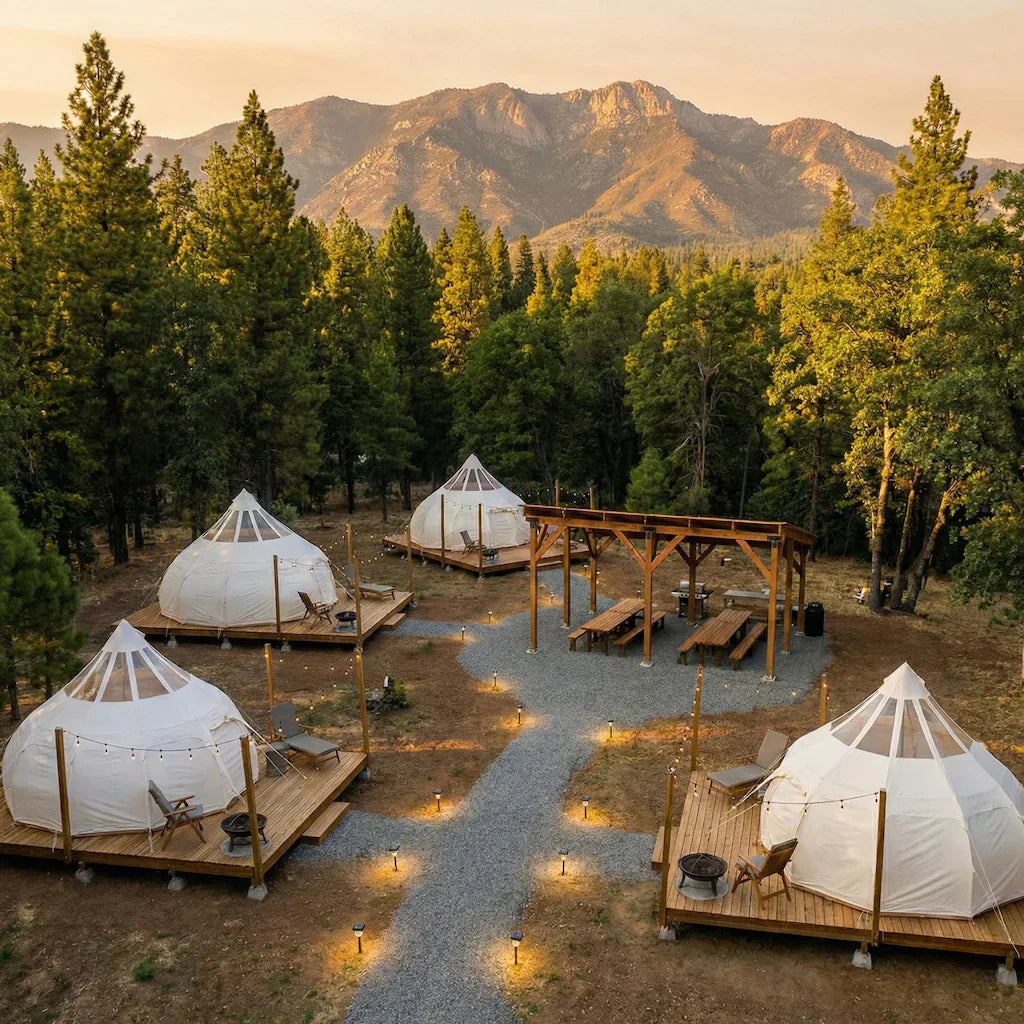 Professional glamping site layout with multiple luxury tents spaced across wooded property with pathways and outdoor living areas