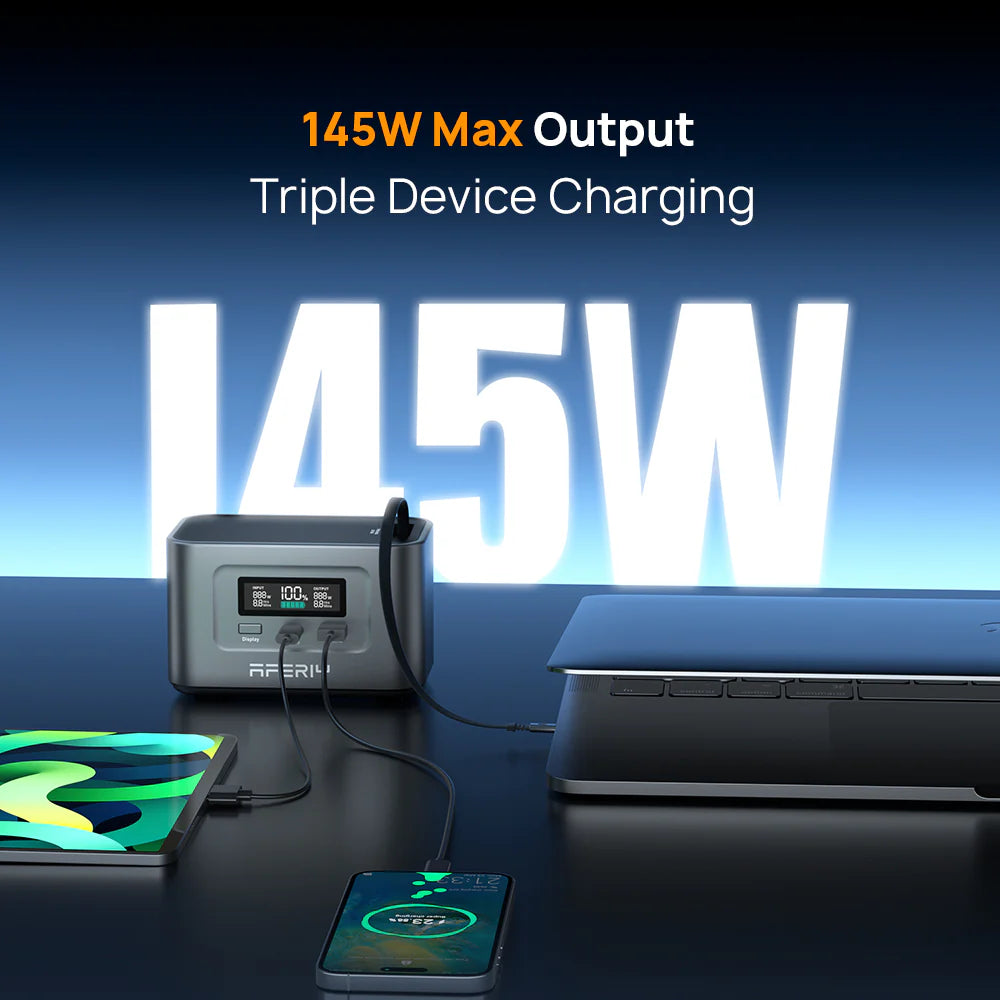 Power station with 145W max output charging a laptop, tablet, and phone on a dark surface.