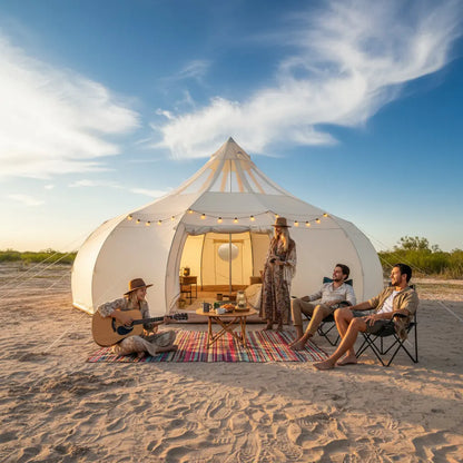 Group of people sitting around a tent in a desert setting with a clear blue sky.