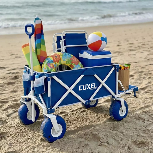 Blue LUXEL beach wagon cart with toys and a cooler on the sand