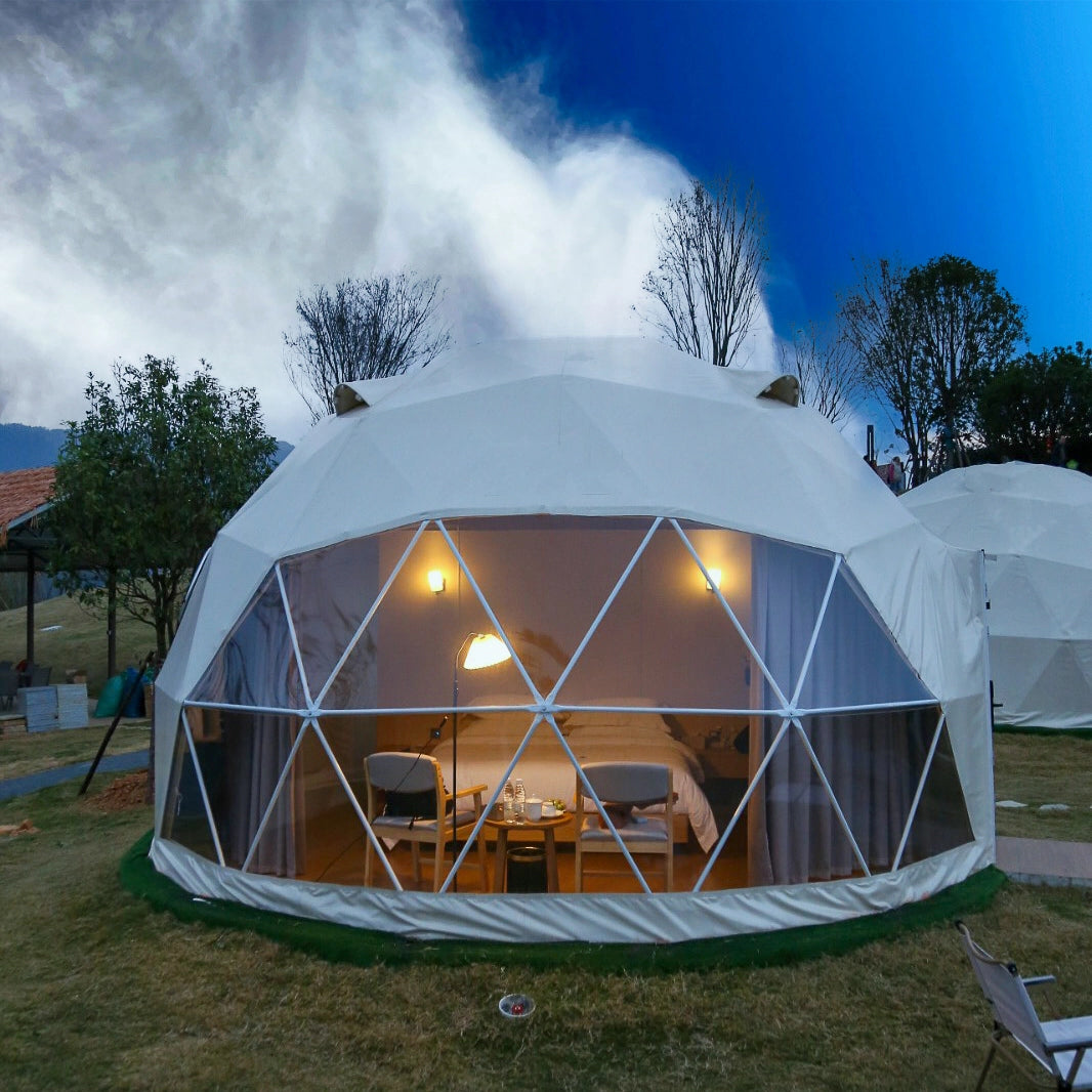 Geodesic dome tent with interior view, surrounded by trees and open sky