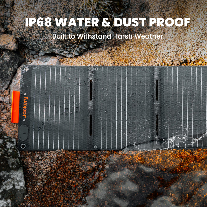 Solar panel on a rocky surface with 'Jackery' branding, text about water and dust proof rating.