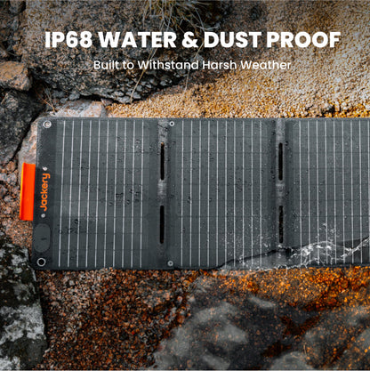 Solar panel on a rocky surface with 'Jackery' branding, text about water and dust proof rating.