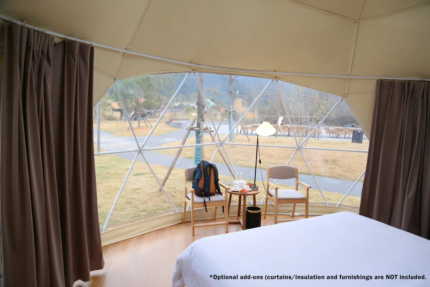 Dome-shaped room with a view of an outdoor area, featuring furniture and curtains.