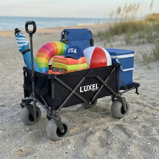 Black LUXEL beach wagon cart with big wheels loaded with beach gear on the sand