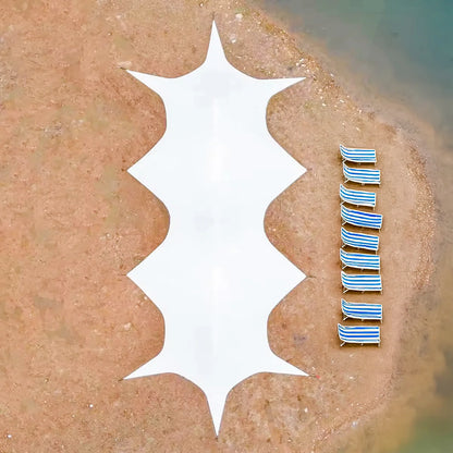 Row of striped beach chairs on a sandy beach next to the Star Cluster canopy